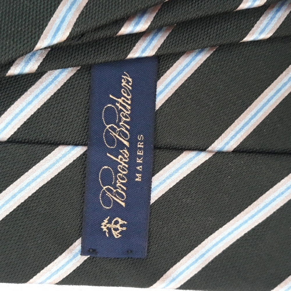 Brooks Brothers blue and gold striped silk tie on a dark green background.